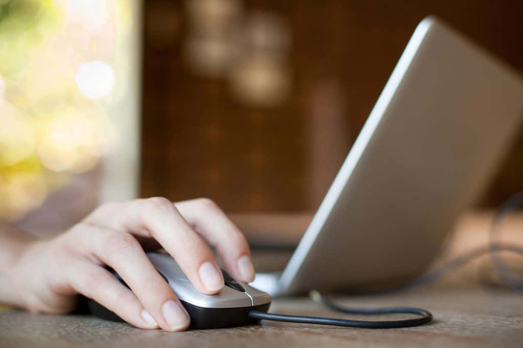 Someone using one hand to control their laptop