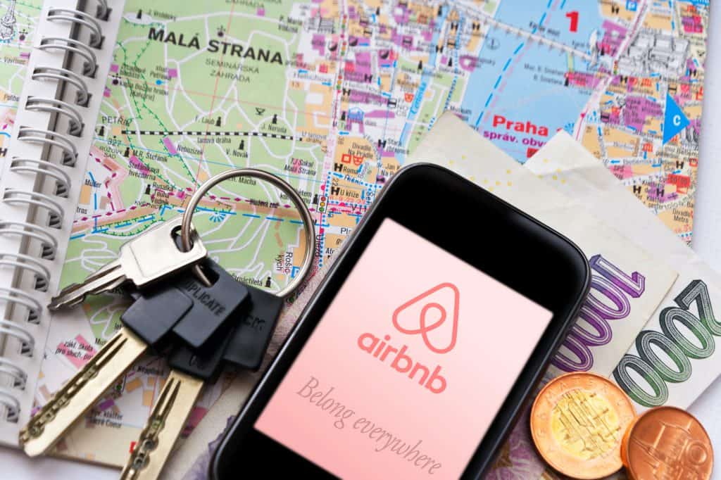 Some keys and money alongside a map and Airbnb app