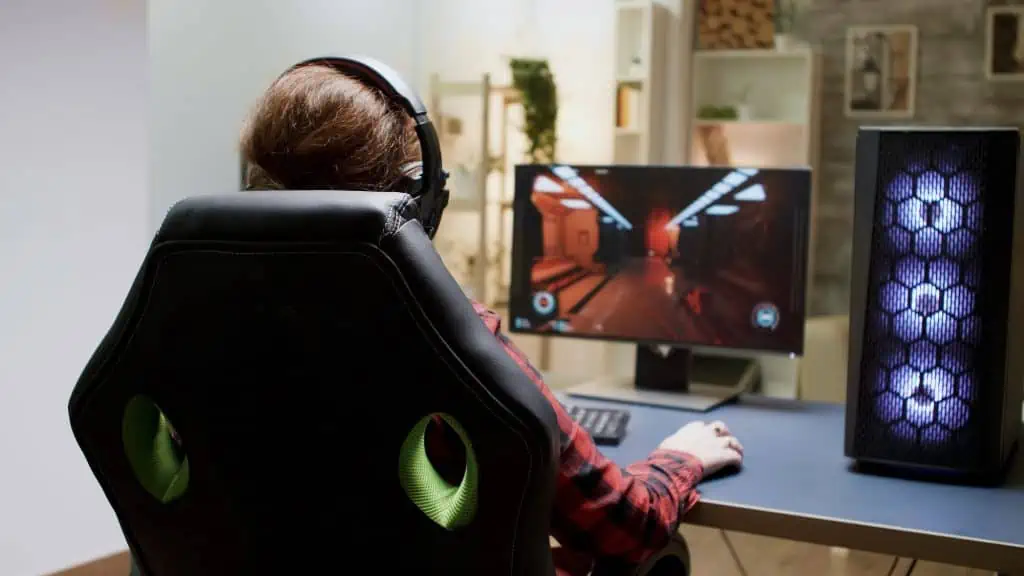 Someone playing a PC FPS game in a gaming chair
