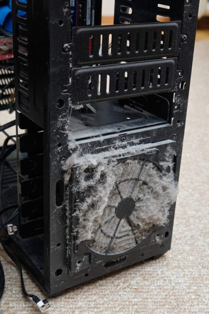 Dust on the computer pc processor cooler with mainboard and computer case fragment.